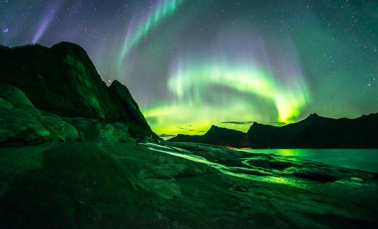 Aurora borealis over mountainous landscape