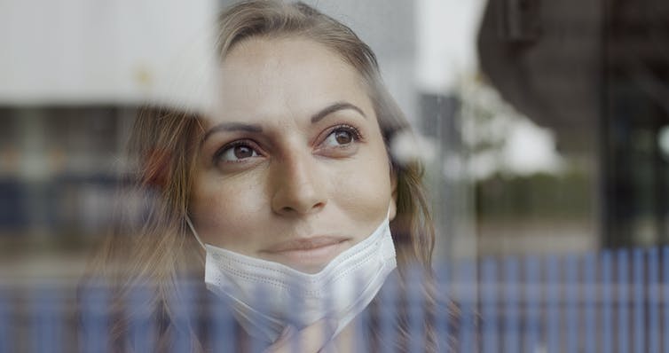 Woman wearing a face mask partially covering her jaw with a positive expression