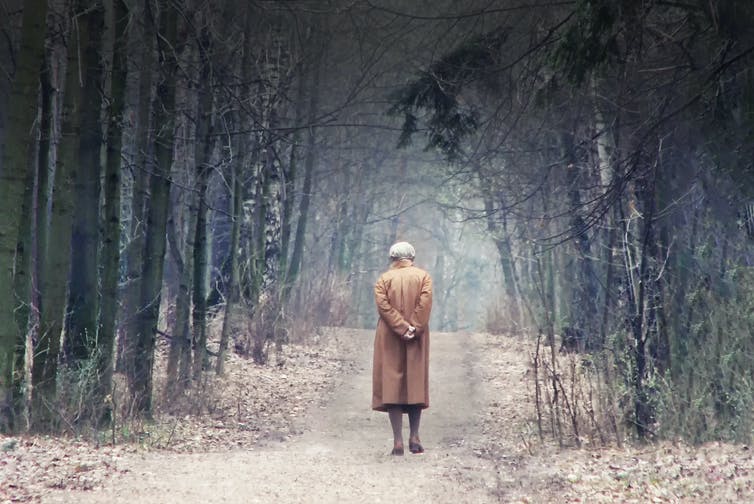 Old lady walking alone in the woods.