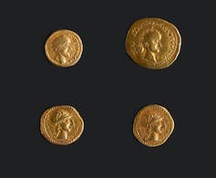 Four gold coins of different sizes showing different profiles of Roman leaders.
